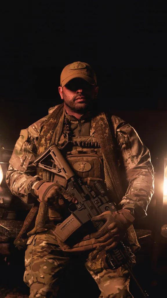 Douglas Pithon com uniforme camuflado em retrato de baixa luz